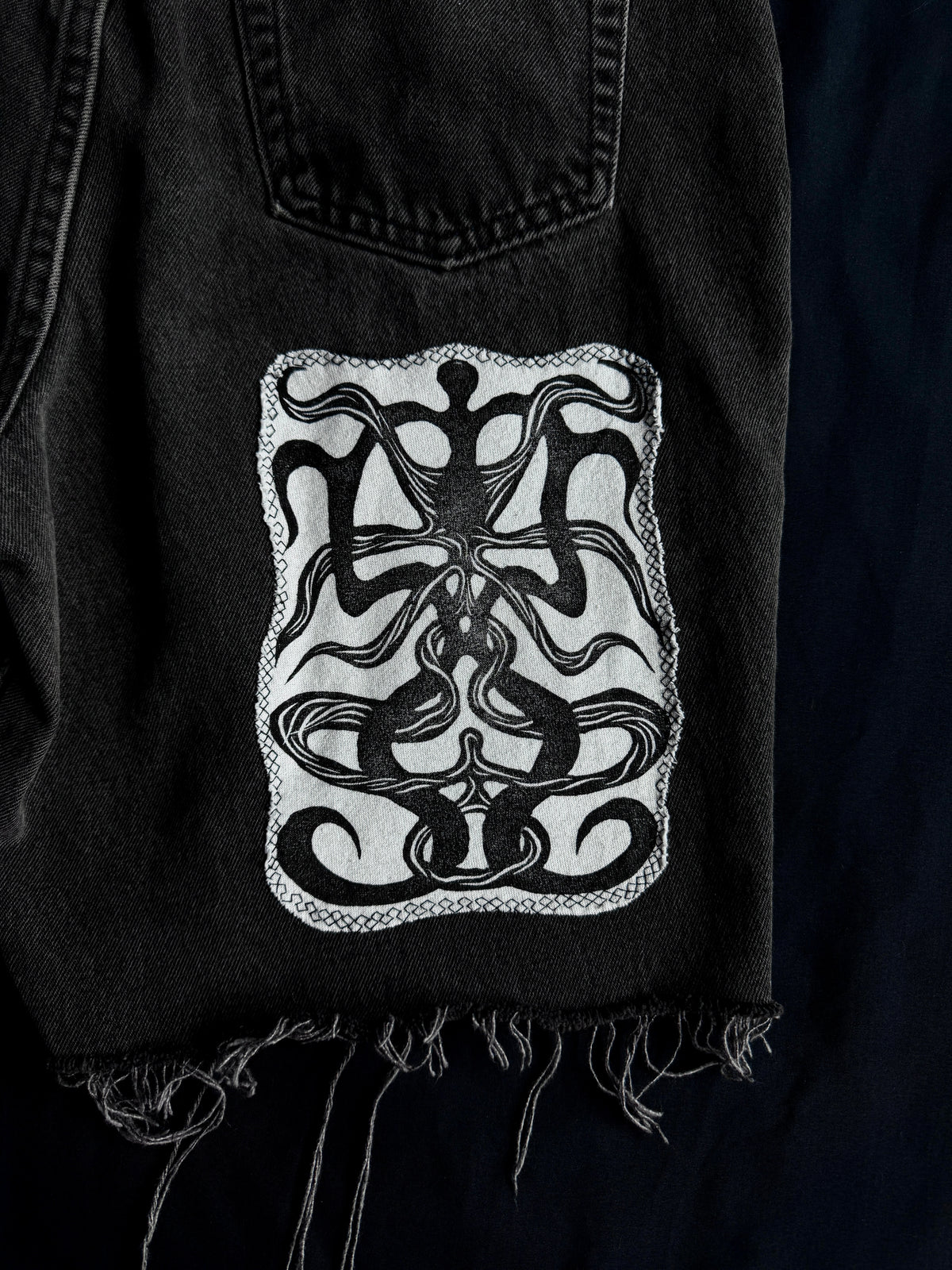 Patched black jean shorts