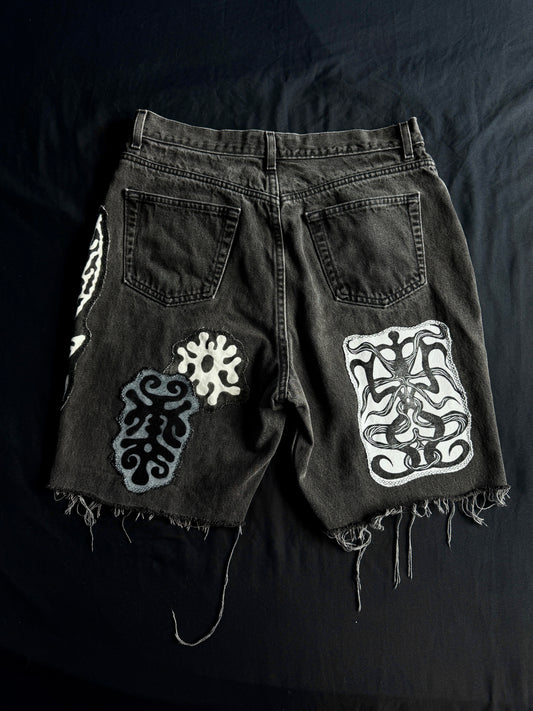 Patched black jean shorts